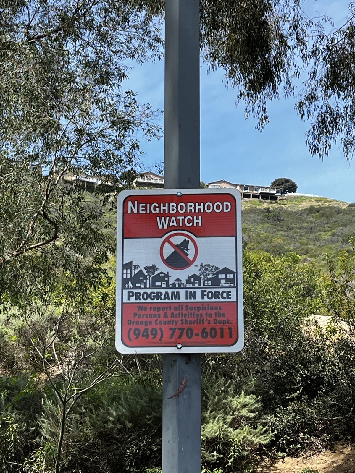 Orange County, California — Masked Bad Guy reflective Neighborhood Watch sign installed in a hillside community